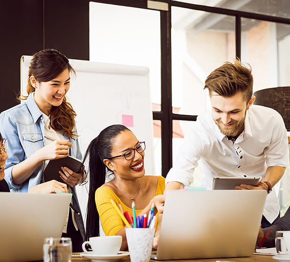 a group of people looking at a laptop